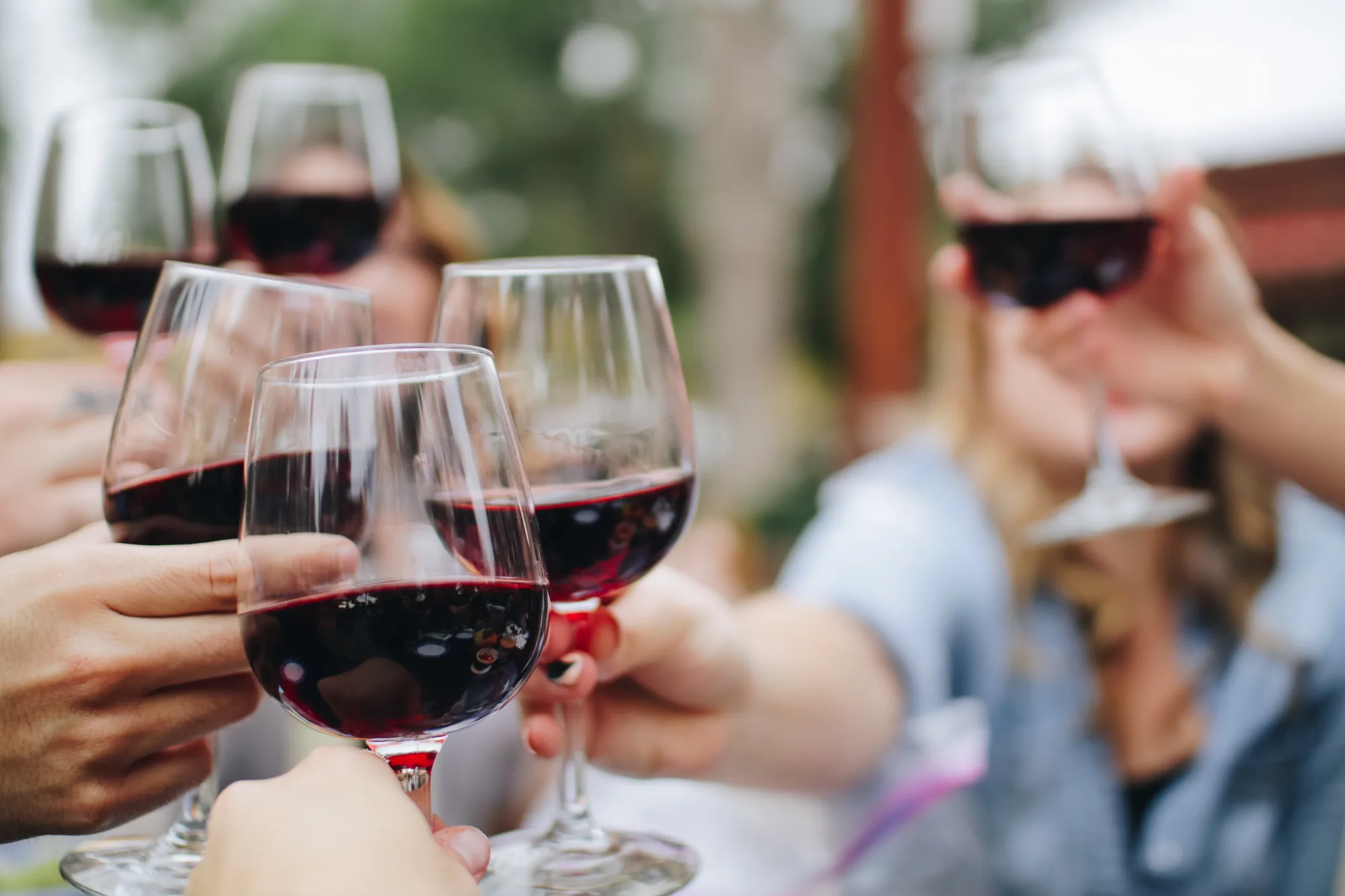 Friends raising glasses of red wine outdoors